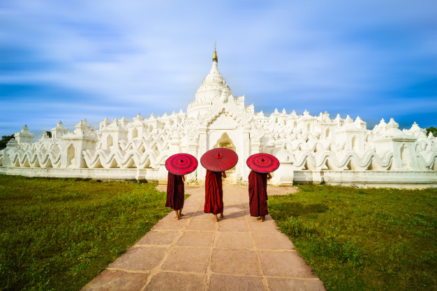 asian-young-monk-holding-red-umbrellas-mya-thein-tan-pagoda-mingun-mandalay_29505-55